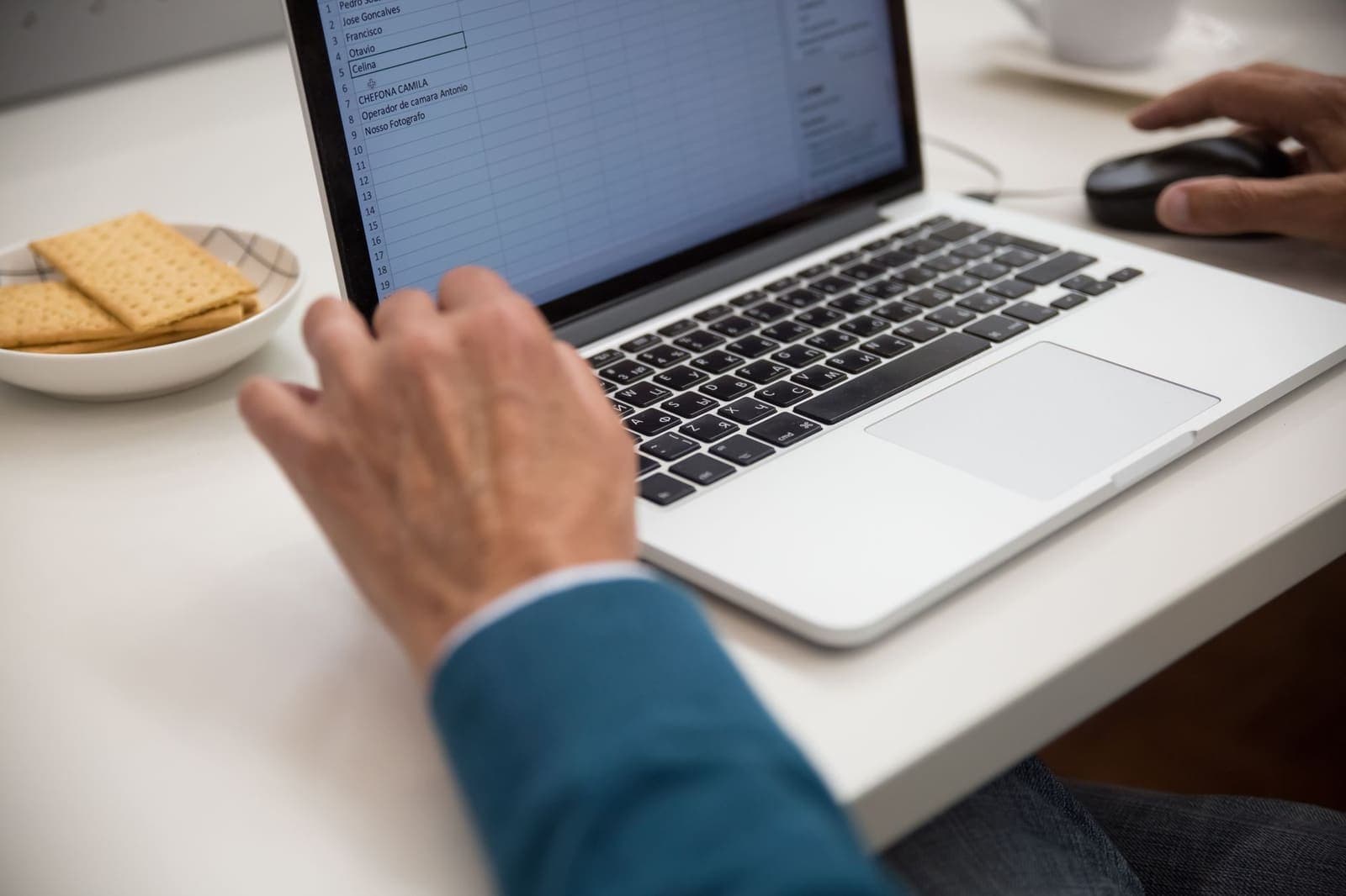 Person working on a spreadsheet on a laptop at a clean desk