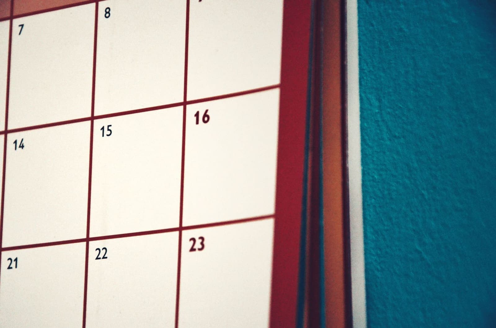 A desk calendar open to January with a yearly planner and coffee cup nearby